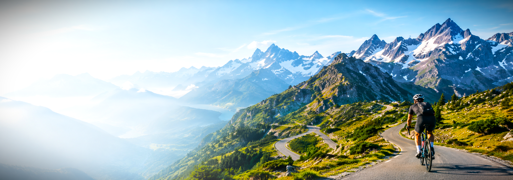 Cyclist climbing misty alpine road